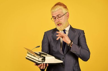 Vintage değerler uzmanıyım. Klasik daktilo. İş adamı geçmişe dönük teknoloji kullanır. Olgun bir adam sakalını sarıya boyadı. Yazar eski alışkanlıkları bırakmaz. İkinci el eşya mağazası. Satıcı vintage nesneler