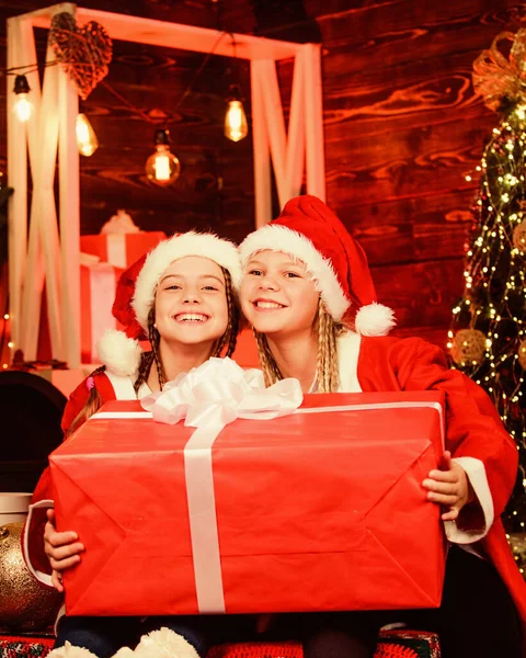 Santa party. Happy new year. Children having fun on christmas eve. Giant enormous surprise. Winter masquerade. Happiness and joy. Girls friends sisters Santa claus costumes received gift. Santa crew — 图库照片