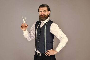 Erkekler için tasarım yapan bir adam. Başarılı sartor çalışmaya hazır. Resmi ve ofis tarzı. Mezura ve makasla terzi. Erkek kıyafetleri terziliği yapan adam. Acımasız adam moda tasarımcısı.