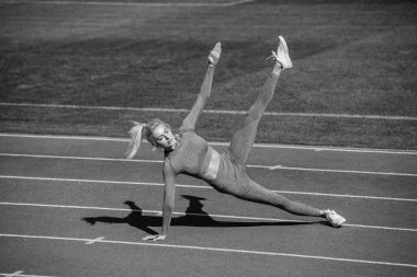 Antrenör ya da koç eğitimi. Mükemmel vücut şekli. sağlıklı ve sportif. Spor giyim bölümündeki seksi fitness kadını. Atletik bayan stadyumun yan tahtasında duruyor. Kadın sporcu spor yapmaya hazır.