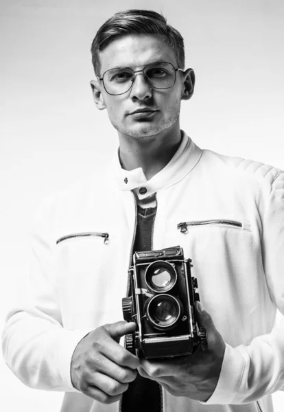 Giovane ragazzo sicuro di sé in abiti urbani bianchi fare foto con macchina fotografica retrò, fotografo di moda — Foto Stock
