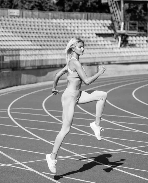 Mulher esporte em sportswear sprinting no estádio pista de corrida antes do treinamento de fitness, resistência — Fotografia de Stock