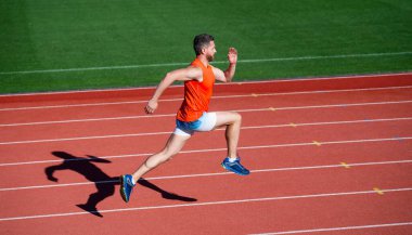 Tam konsantrasyon. Stadyum koşu pistinde koç. Dayanıklılık ve dayanıklılık. Yarış pistinde koşucu. Meydan okuma ve rekabet. Maraton hızı. Sporcu sporcu kazanmak için hızlı koşar. Başarılı fitness koşucusu