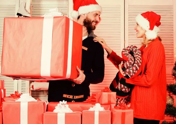 彼女にとっては大きな驚きだ。クリスマスのプレゼントを用意する。新年の贈り物。サンタクロースからの贈り物。ギフトボックスを持つ男と女。家族の買い物。季節販売。大きなギフトボックスを持つ男。幸福を広める — ストック写真
