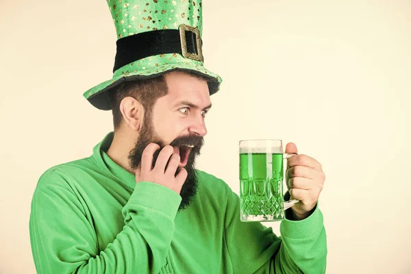 Irländsk för en dag. Skäggig man som skålar för helgonets patricks dag. Irländsk man med skägg dricker grön öl. Firar helgonpatrickernas dag i baren. Hipster i pysslad hatt med ölmugg — Stockfoto