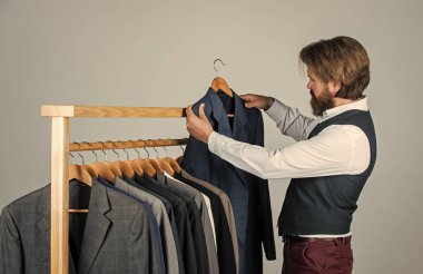 Genç mükemmeliyetçi. İş adamı. Kendine güvenen terzi erkek ceketi tasarlıyor. Mezura takan yakışıklı bir sartor. Erkek güzellik ve moda. Sakallı adam, terzi kıyafetleri. resmi ve ofis dolabı