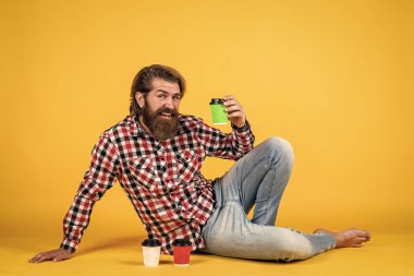 Çay ya da kahve içmek. Günaydın. Evde sabah havası var. İlham konsepti. Hipster adam kahve içer. Beyaz bardak tutan yakışıklı sakallı adam. Bardakla içecek.