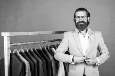 Her zaman şık. Tarz ve insan konsepti. Yakışıklı, sıradan giyimli, takım elbiseli ve seçici bir adam. Askıda duran şık erkek kıyafetleri. İş modası tarzı. kuru temizleme servisi