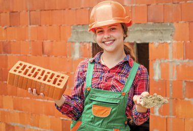 Kafasında tuğla olan mutlu çocuk mühendis.