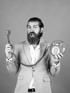 Telefondaki adam. Genç adam telefonda konuşuyor. İş adamı klasik telefondan konuşuyor. Erkek sabit telefondan konuşuyor. Modern yaşamda klasik teknoloji. Hat meşgul. İlgi önce gelir