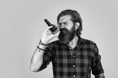 Mikrofonlu erkek şarkıcı. Karaoke konsepti. Erkek şarkıcı müziği sever. Vahşi adam mikrofonla şarkı söylüyor. vokal okulu. Vahşi ve taş gibi. Sakallı adam damalı gömlek giyip şarkı söylüyor.