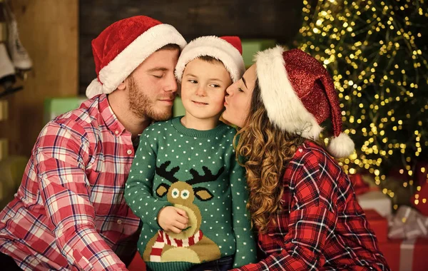 Father and mother with child stay home on holidays. merry christmas. mom dad and small kid have fun on party. happy family celebrate new year. parents with son wear santa hat — Fotografia de Stock