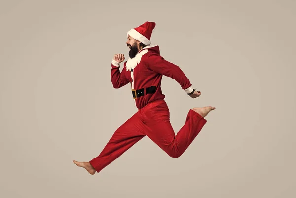 Frohe Feiertage. Weihnachtsmann mit Hut eilt zum Weihnachtseinkauf. Ein bärtiger Mann im Weihnachtskostüm. Freiheitsbegriff. glücklicher Kater hat einen lustigen Blick. Winterurlaubsfeier. Neujahrsspaß — Stockfoto