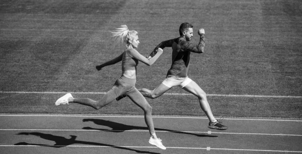 Entrenamiento extremo. pareja de deportes corren rápido para ganar. exitosos velocistas de fitness. hombre atlético y mujer sexy compiten en sprint. macho y hembra en pista de atletismo. estilo de vida saludable. velocidad maratón — Foto de Stock