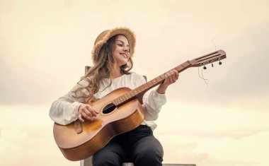 Yeni şarkım. Şarkıcı. Dışarıda gitar çalan mutlu genç kız. Mutlu çocukluk.