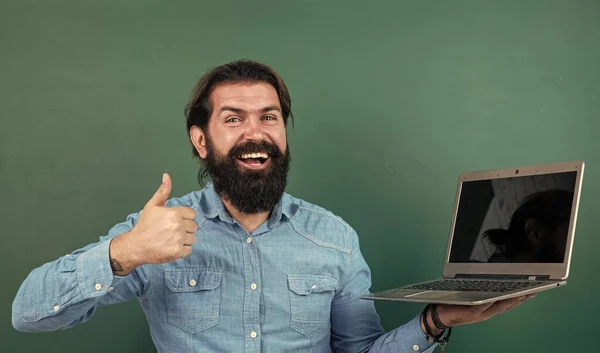 Alegre empresario exitoso y seguro de sí mismo con barba trabajando en el ordenador portátil en línea, era digital —  Fotos de Stock