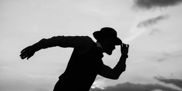 Man dancer silhouette pose with hat against sunset sky, dancing — Stock Photo, Image