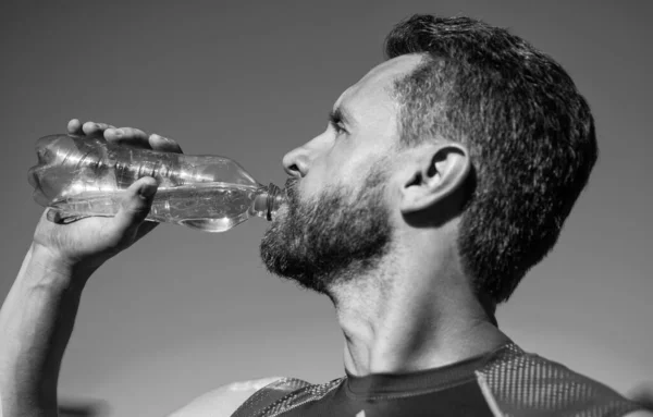 Hombre barbudo beber agua debido a la sed después del entrenamiento, deporte e hidratación — Foto de Stock