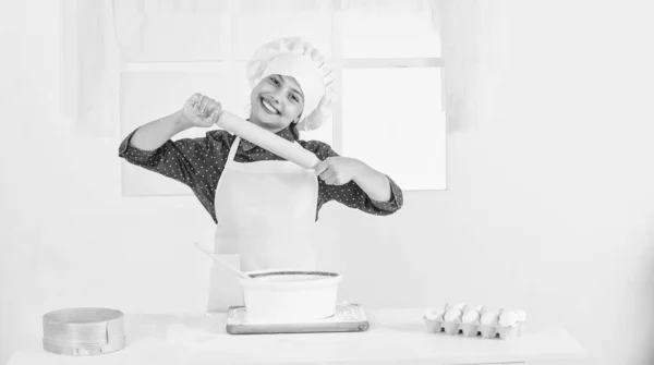 주방용 기구. 셰프 복장에 모자쓴 애. 반죽을 준비하는 십 대 소녀. 레시피로 케이크를 만드는 것입니다. 먹을 시간이야. 부엌에서 요리하는 행복 한아이. 부엌에서 구운 쿠키. 전문적 이고 숙련 된 제빵사 — 스톡 사진