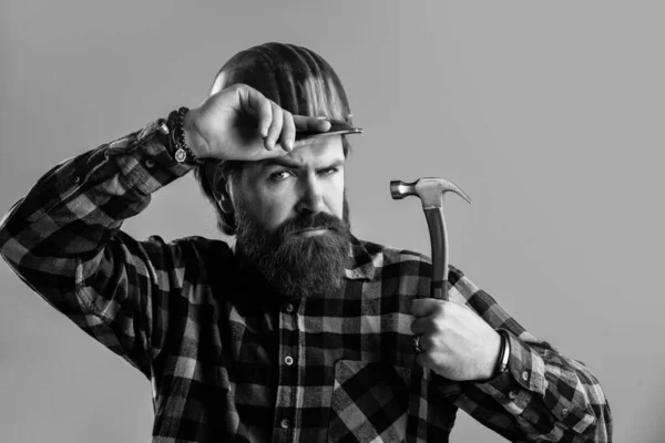 Bearded male hipster in checkered shirt and laborer helmet, working — Stock Photo, Image