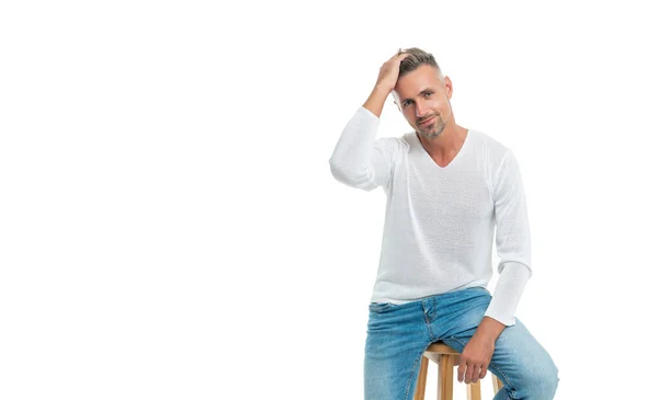 Mężczyzna moda model w casual styl ubrania siedzieć na krześle izolowane na białym z miejsca kopiowania, moda. — Zdjęcie stockowe