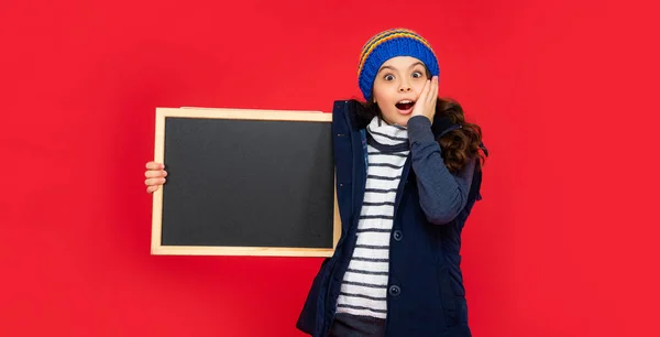 10代の少女がコピースペースで黒板を持ってショックを受けました。子供は学校に戻る。広告. — ストック写真