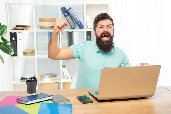 兴奋的商人高兴地尖叫着，在办公室的笔记本电脑上做着获胜的手势，胜利 — 图库照片