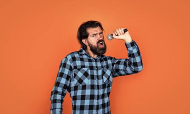 Duygusal sakallı adam karaoke 'de mikrofonla şarkı söylüyor, müzik tarzında.