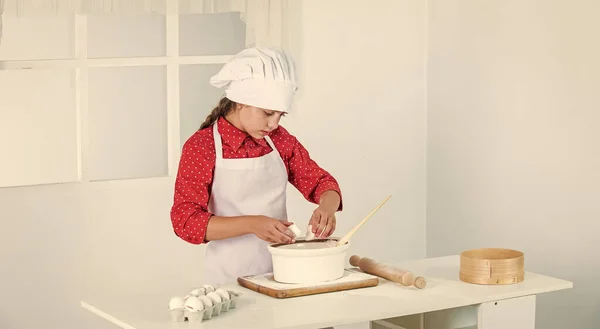 Verantwoordelijk kind heeft plezier met eten in de keuken. Kind en bakken. Gezond eten en levensstijl. meisje dat deeg maakt van bloem en eieren. Dieet en gezondheid. Culinaire school. traditionele keuken — Stockfoto