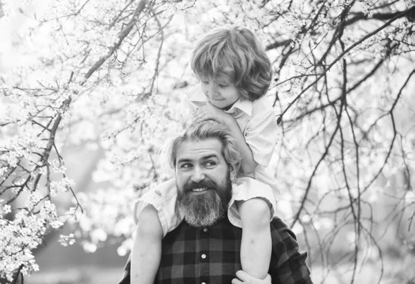 Cheerful father playing with his child in park. Handsome dad with his little cute son. enjoy bloom and nature together. happy family day. spring is coming. just have fun. love concept — Stock Photo, Image