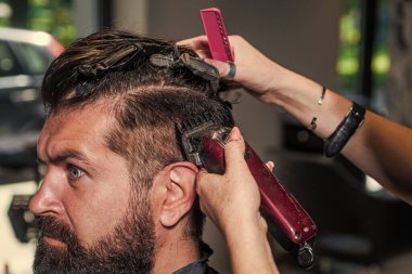 Usta Barber saç stilini ve saç stilini elektrikli tıraş makinesiyle yapıyor, Berber Dükkanı kavramı.