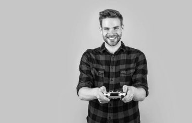 Moda saç stili olan şık bir adam kareli gömlek giyer video oyunu oynar, hobi yapar.