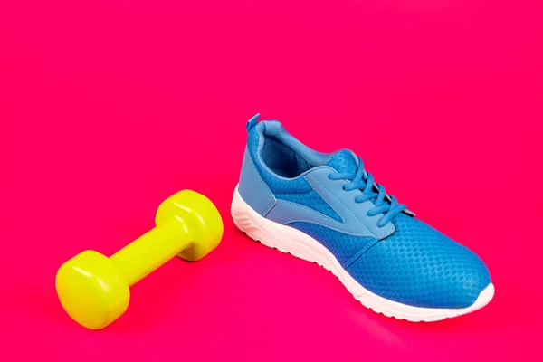 Footwear for training with dumbbell on pink background, sport — Stock Photo, Image