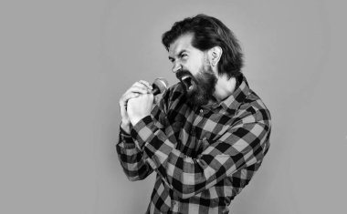 vahşi sakallı erkek şık görünümlü mikrofonla şarkı söylüyor, şarkıcı