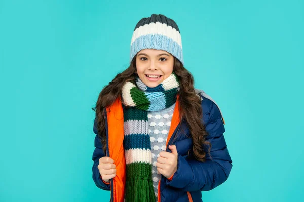 Moda de inverno. criança emocional com cabelo encaracolado em chapéu e cachecol. menina adolescente em jaqueta puffer — Fotografia de Stock