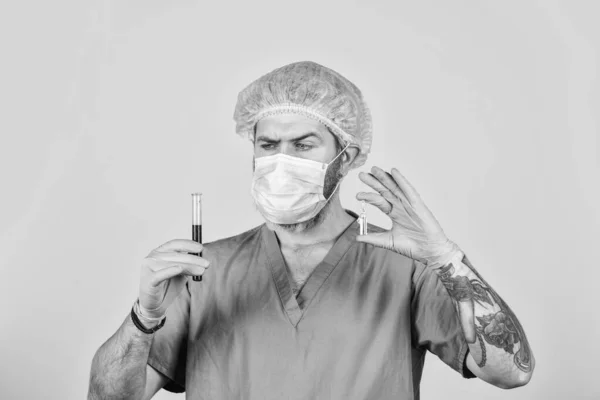 Ιατρικός επιστήμονας κατέχει δοκιμαστικούς σωλήνες. γιατρός που φοράει χειρουργική μάσκα κατά τη δοκιμή. Η νοσοκόμα εξετάζει δείγματα αίματος στο εργαστήριο. Τι είναι ο κορωνοϊός. φάρμακο κατά του νέου τύπου γρίπης των ιών. επιδημία — Φωτογραφία Αρχείου