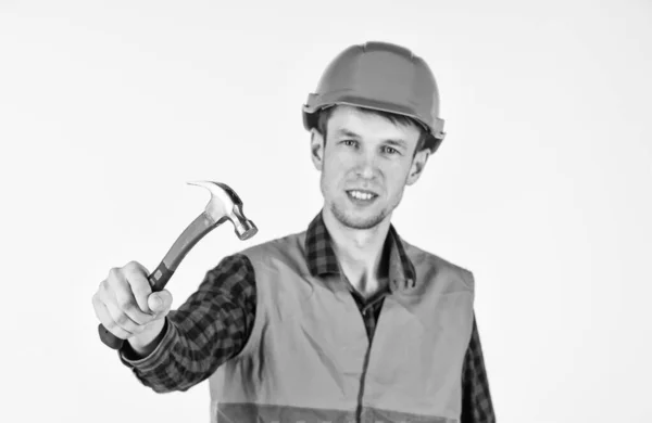 Een reparateur in uniform. Man werkt met hamer. echte bouwvakker in helm. timmerman klaar om te werken. reparatieapparatuur voor bouwgereedschap. Jonge werknemer is ingenieursassistent. alles herstellen — Stockfoto