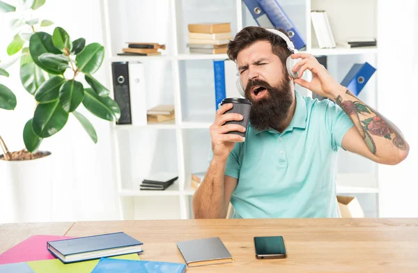 Hombre feliz cantando para llevar taza escuchando la canción en los auriculares en la oficina, música —  Fotos de Stock
