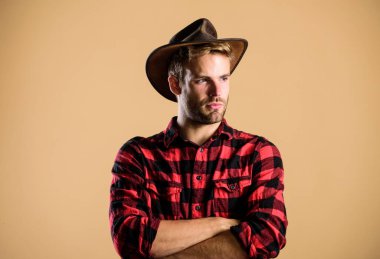 Vahşi batı rodeosu. Şapkalı yakışıklı adam. Kırsal kesimdeki kovboy. Batı. Çiftlikte kareli gömlek. Klasik tarz adam. Vahşi Batı eski kovboy. Batı kovboy portresi