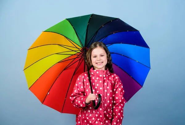 화려 한 우산을 두른 행복 한 어린 소녀. 가을 패션. 쾌활하고 명랑 한 성격의 어린이. 비를 막아주는 장치. 레인보우. 비옷입은 작은 소녀. 편안하고 유행같은 느낌 — 스톡 사진