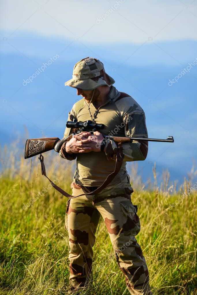 Fotos de Fuerzas del ejército. Ropa militar de hombre con arma. Guerrero  brutal. Rifle para cazar. Listos para disparar. Cazador de rifle. Hunter  montañas paisaje fondo. Enfoque y concentración cazador experimentado 