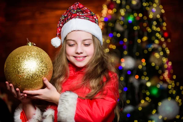 Şenlikli atmosfer noel günü. Kız Noel Baba kostümü büyük noel ağacı süsleri içerir. Noel süsleri. Etraftaki her şeyi dekore etmeye bayılırım. Parlak büyük bir oyuncak. Mutlu Noeller. — Stok fotoğraf