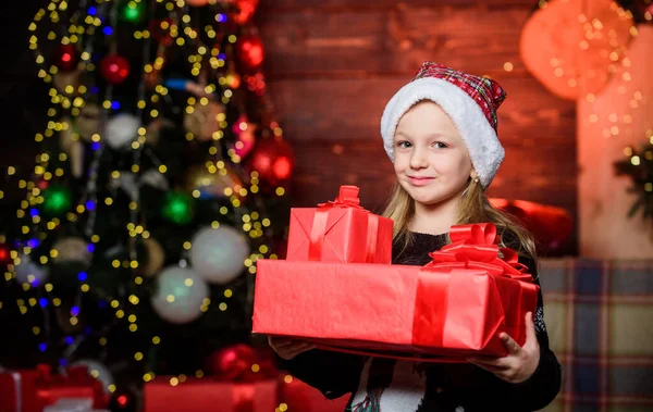 Girl cute child hold wrapped gift near christmas tree. Holiday party that actually sounds fun. Merry christmas. Kid adorable wear santa hat celebrate christmas. Buy christmas gift. Winter shopping — Stock Photo, Image
