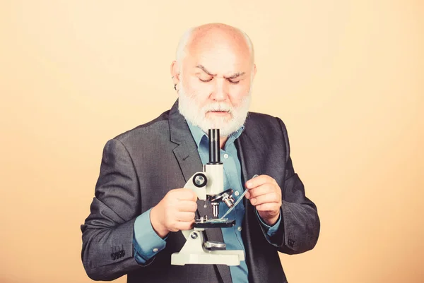 Reifer Mann formalen Anzug mit Mikroskop. Doktorarbeit und Postdoktorandenstelle. Molekularbiologie promovierte. Biologie-erfahrener Dozent. Universitätsprofessor. Wissenschaftler Mikrobiologie — Stockfoto