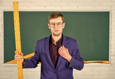 Tahtadaki adam. Okula dönüyorum. Boyutu ne? Geometri favori konusu. Erkek öğretmen matematik cetvelini tutuyor. Eğitim ve okul konsepti. Kök okul disiplini. Matematik ve insanlar kavramı