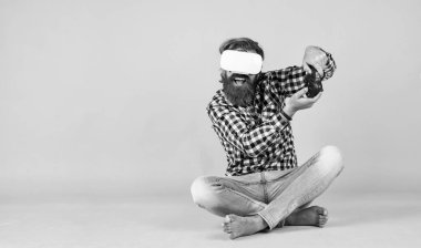 Sanal gerçeklik gözlüklü bir adam. Sakallı hippi modern teknoloji kullanır. Oyun konsolu. Geleceğin teknolojisi. Görsel gerçeklik kavramı. Adam VR kulaklık kullanma deneyimi kazanıyor.