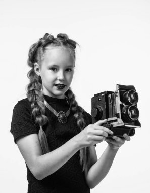 Retro kameralı şık bir kız beyaz fotoğrafçılıkta izole edilmiş bir fotoğraf çekiyor.