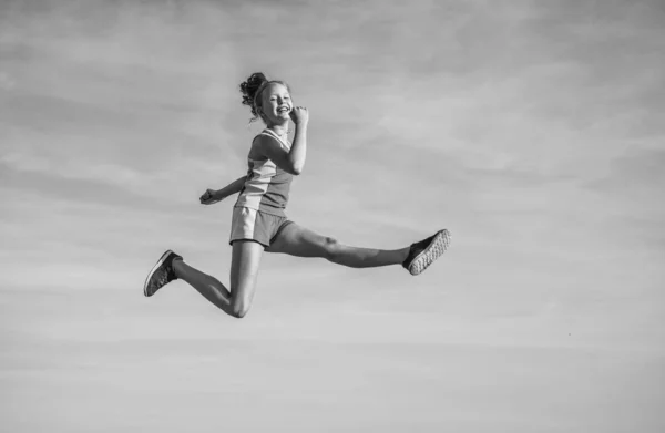 Criança alegre atleta ou ginasta saltar no fundo do céu, energia — Fotografia de Stock