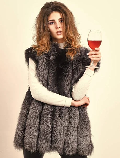 ファッションモデル長毛毛皮のコートやベストはワイングラスを保持します。ファッショナブルな女性は贅沢が好きです。女の子は豪華なライフスタイル属性をお楽しみください。女性は高級毛皮の服を着てワインを飲む。高級ワイナリーコンセプト — ストック写真
