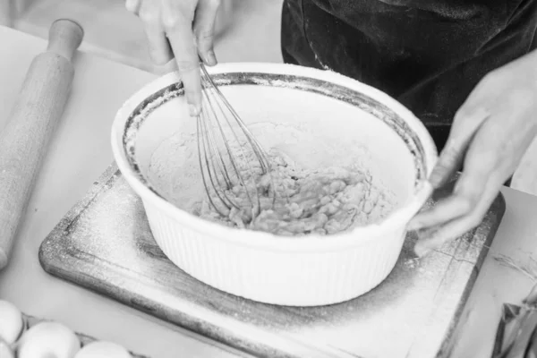 Konyha és konyha. Boldog gyermekkort. gyermek visel szakács egyenruhát. A séflány keveri a lisztet és a tojást a habverővel. A gyerek ételt főz a konyhában. pályaválasztás — Stock Fotó